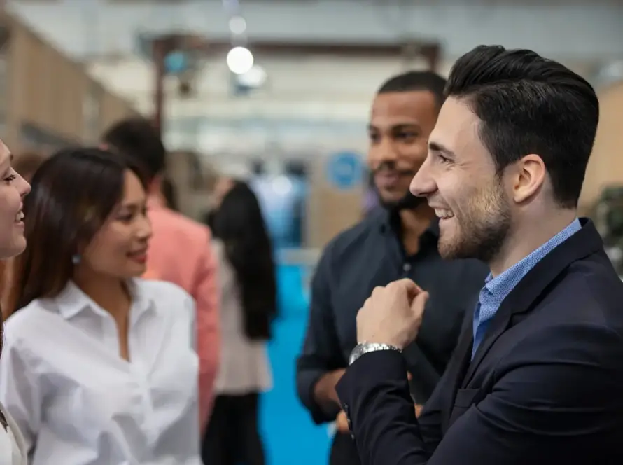 Professionals engaging in conversation at a networking event, smiling and interacting in a business conference setting